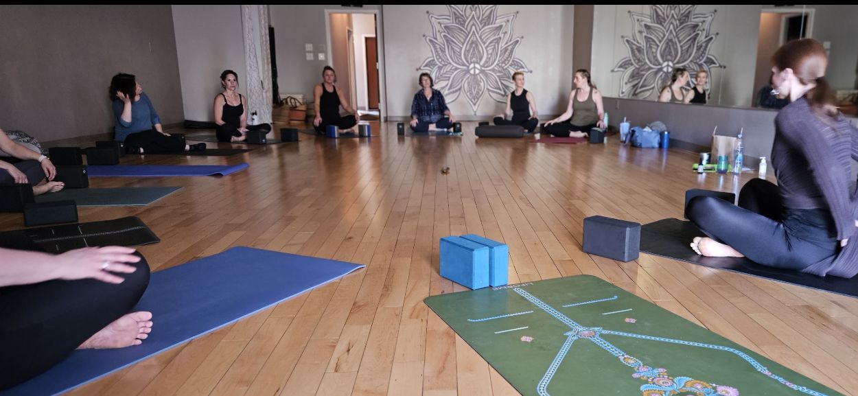 A yoga class gathered in a bright neighborhood studio